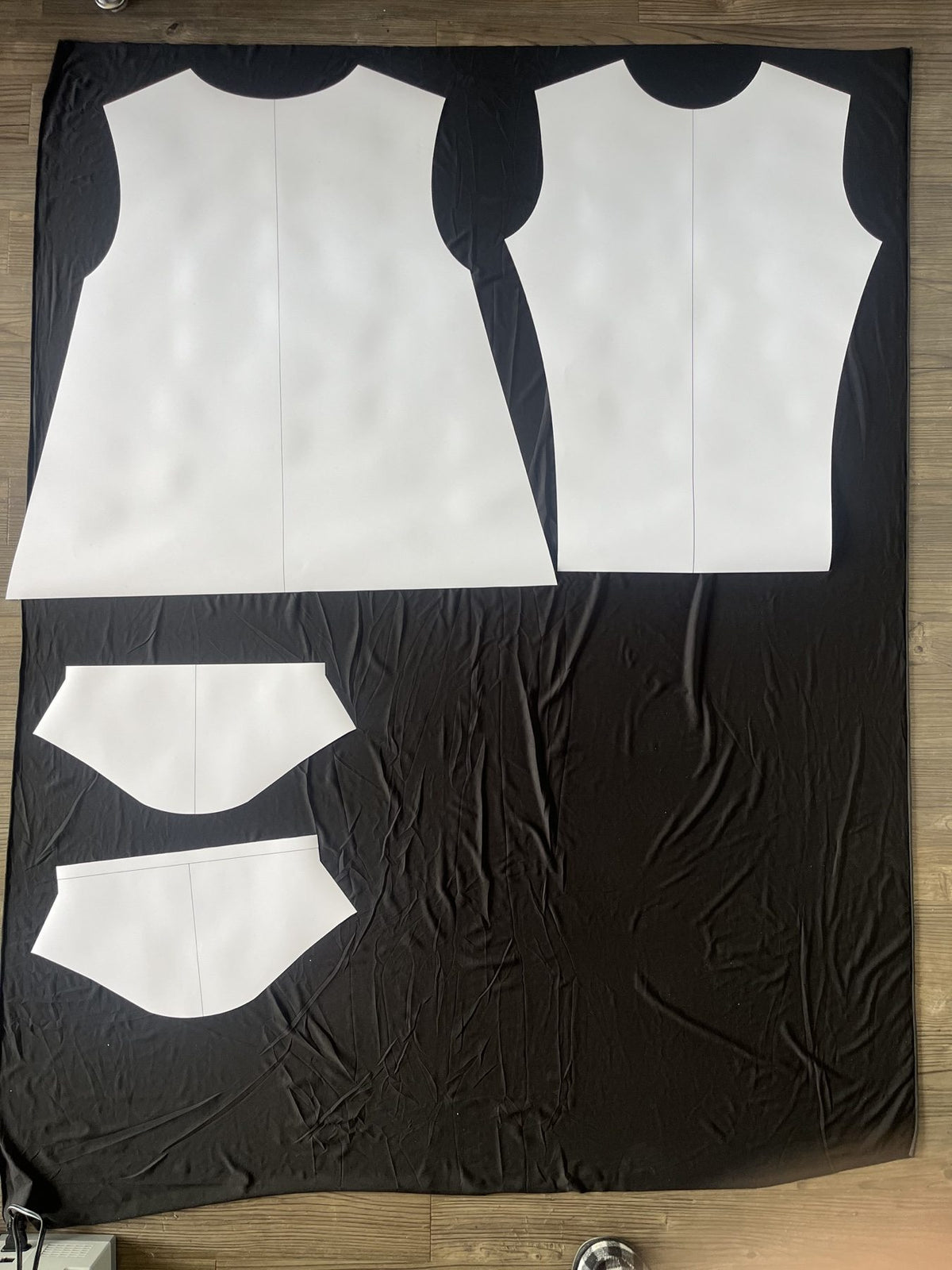 Paper body and sleeve patterns arranged on dark fabric