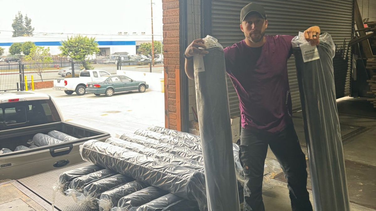 Fabric rolls being collected at a loading dock beside a pickup truck