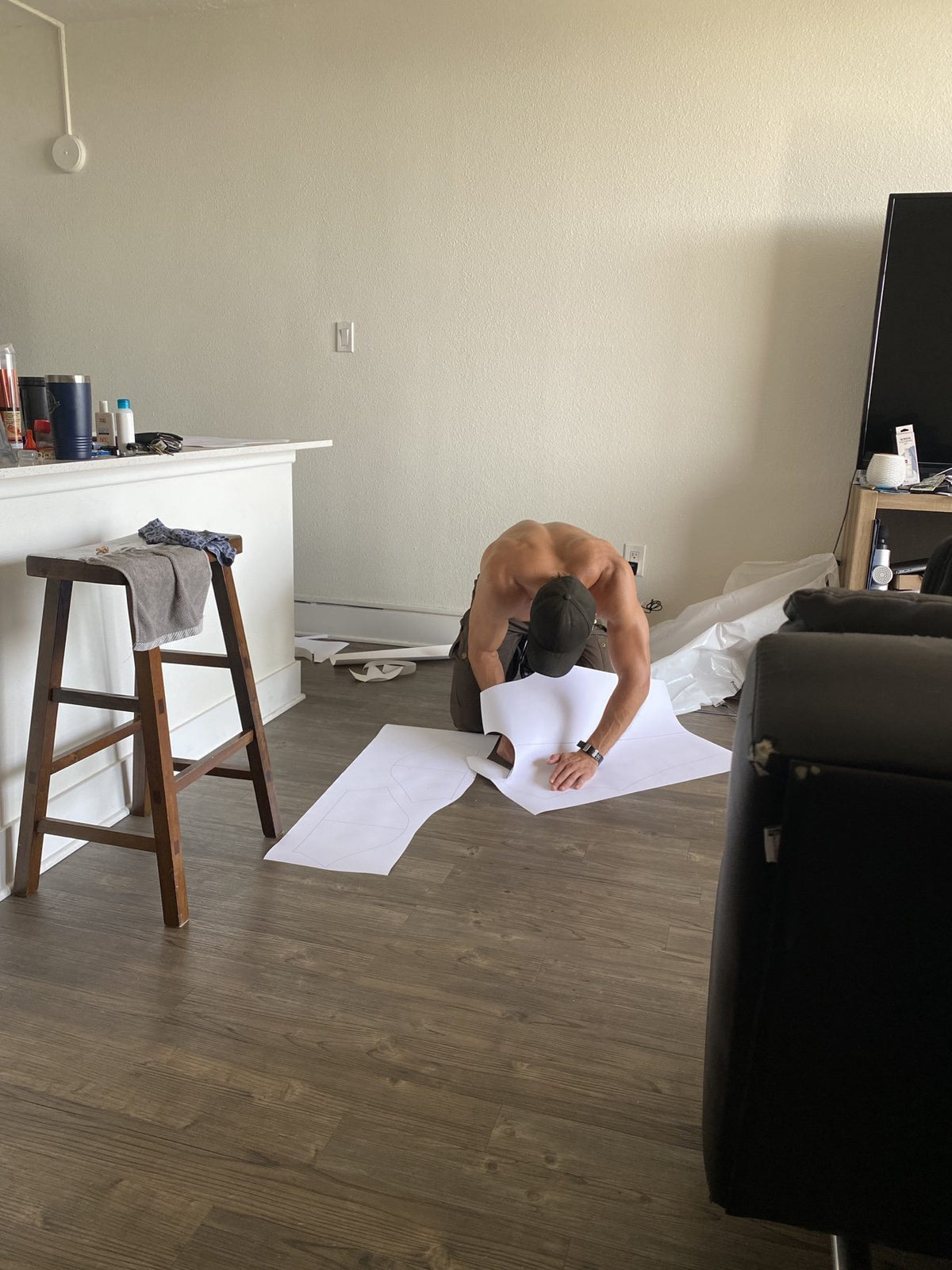 Paper garment patterns being cut on the floor of the early home workspace