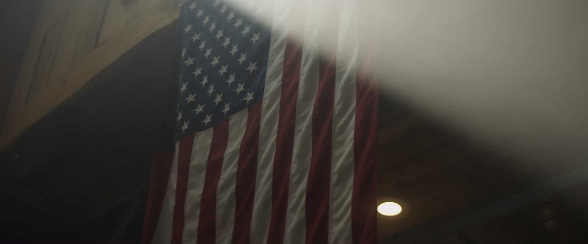Flag of the United States hanging inside a wooden house